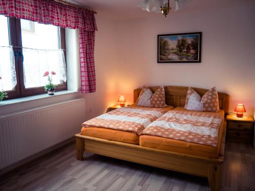sypialnia z łóżkiem i 2 oknami w obiekcie Pfeiffer´s Ferienwohnung w mieście Diehsa