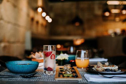 a table with a plate of food and a drink at Exmo Hotel by Olivia in Porto