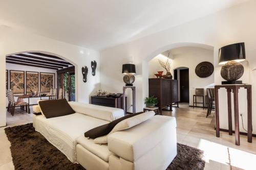 Una sala de estar con un sofá blanco y una mesa. en Villasimius Home, en Villasimius