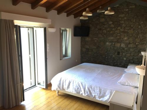 a bedroom with a bed and a stone wall at Loukia in Kondiás
