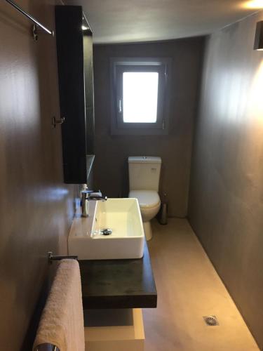 a bathroom with a sink and a toilet and a window at Loukia in Kondiás