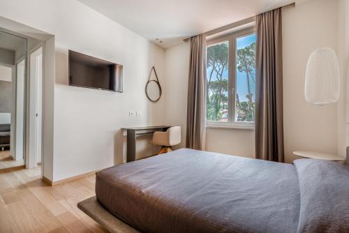a bedroom with a bed and a tv and a window at Resort Miramonti in Forte dei Marmi