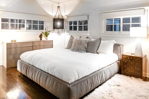 1 dormitorio con 1 cama grande con sábanas y almohadas blancas en Foxden, en Los Ángeles