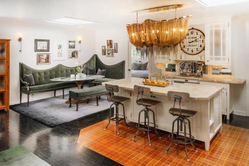 a kitchen with a bar and chairs and a clock at Foxden in Los Angeles