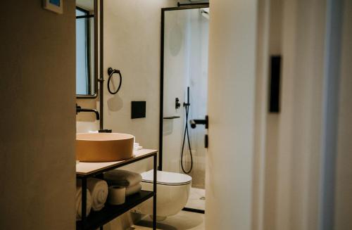 a bathroom with a toilet and a sink and a shower at Exmo Hotel by Olivia in Porto