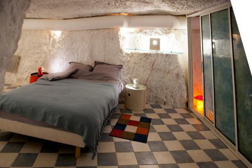 ロシュコルボンにあるGîte de l'oppidumのチェックフロアのベッドルーム1室(ベッド1台付)