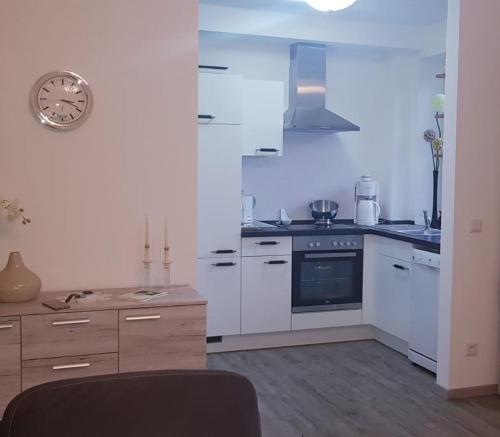 a kitchen with white appliances and a clock on the wall at Ferienwohnung Ostseepalast in Timmendorfer Strand