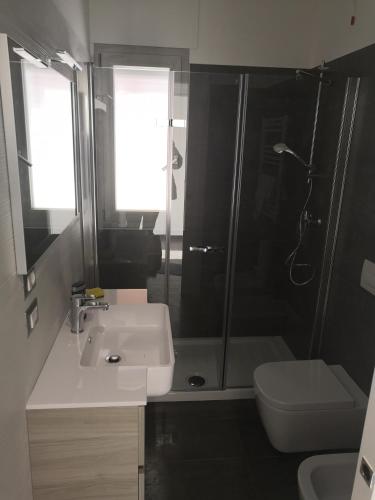 een badkamer met een douche, een wastafel en een toilet bij infinito in Alba Adriatica