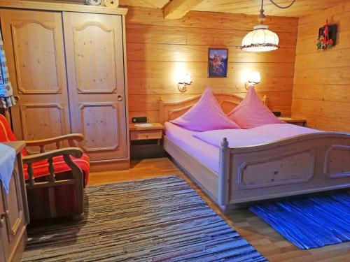 ルーポルディングにあるAlmbrünnerl die Almhütte auf der Raffner Almのベッドルーム1室(ピンクの枕が付いたベッド1台付)