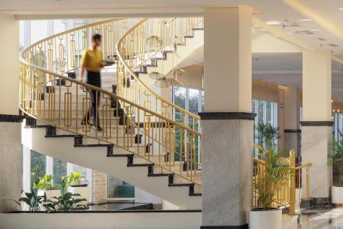 a man walking down a spiral staircase in a building at Horison Ciledug Jakarta in Jakarta