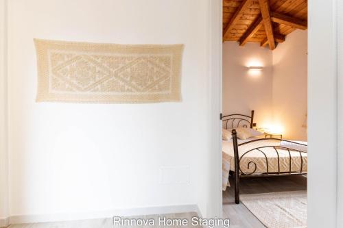 a bedroom with a bed and a white wall at Villa Vitto - Sleep & Go in Capoterra