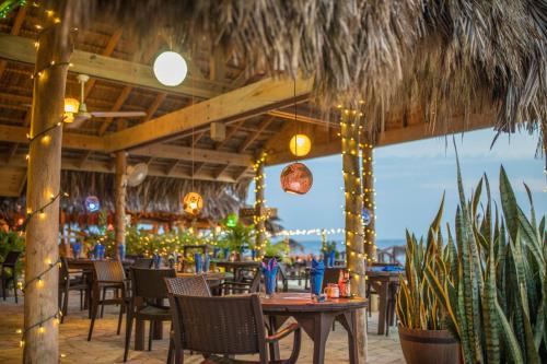 a restaurant with tables and chairs and lights at Catcha Falling Star in Negril