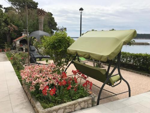 a green umbrella sitting next to some flowers at Apartment One in Rab