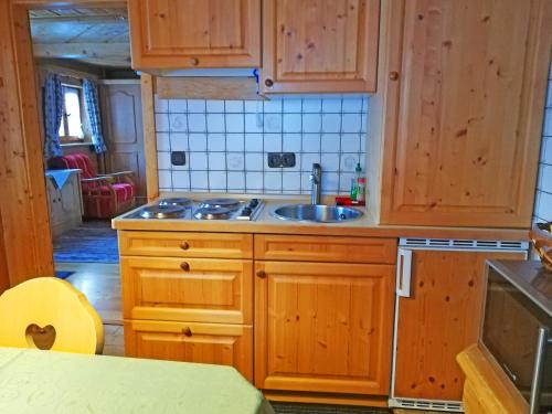 eine Küche mit Holzschränken und einem Waschbecken in der Unterkunft Almbrünnerl die Almhütte auf der Raffner Alm in Ruhpolding
