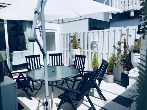 een tafel en stoelen op een patio met een parasol bij Casa Blanca Zandvoort in Zandvoort