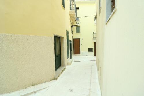 un vicolo tra due edifici con una porta verde di Corte Fiormi' a Tuglie