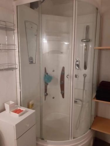 une douche avec une porte vitrée dans une salle de bain dans l'établissement Chez Eve, à Nîmes