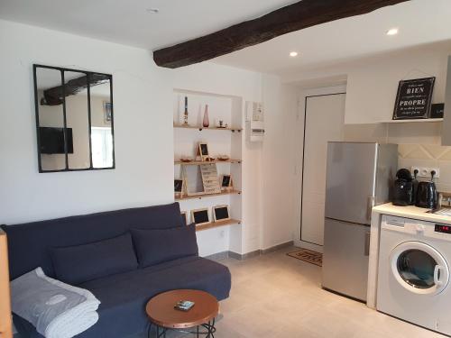 - un salon avec un canapé bleu et un réfrigérateur dans l'établissement A Casetta di SANTA MARIA, à Furiani