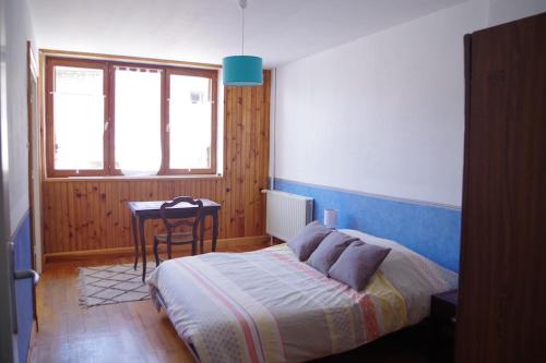 une chambre avec un lit et une table dedans dans l'établissement Sur le plateau - Logement indépendant St Genest Malifaux, à Saint-Genest-Malifaux