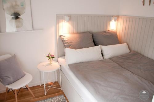 a bedroom with a bed with a chair and a table at Noorden Stuuv in Wittenborn