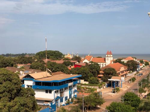 a town with a blue and white building and a street at Bissau Royal Hotel in Bissau