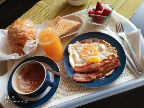 un vassoio per la colazione con uova, pancetta, pane tostato e una tazza di caffè di B&B Baggere a Napoli