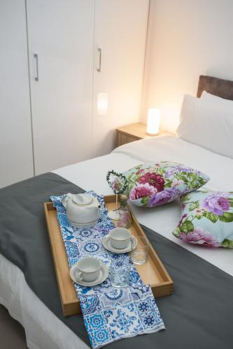 a table with a tray and plates and flowers on a bed at DREAM APPARTMENT 2 PEREA in Perea