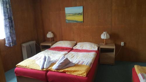 a bedroom with a bed and two tables and two lamps at Ferienwohnungen am Werbellinsee in Schorfheide