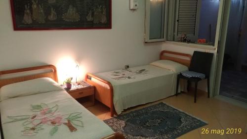 a room with two beds and a table and a window at Villetta Carati in Torre dell'Orso