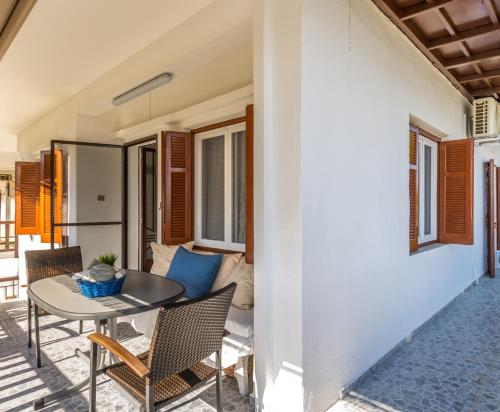 a patio with a table and chairs and a couch at Chalkidiki Beachfront Apartment in Nea Iraklia