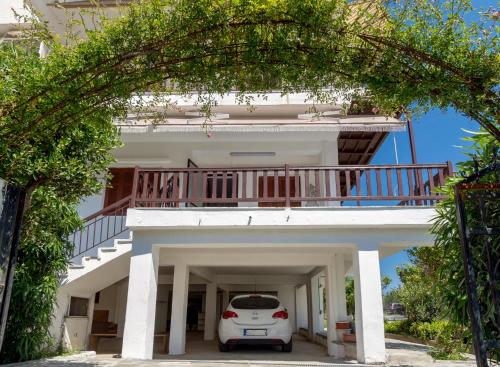 a white car parked in front of a white house at Chalkidiki Beachfront Apartment in Nea Iraklia