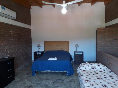 1 dormitorio con 1 cama azul y 2 mesitas de noche en Complejo M&M en Bialet Massé