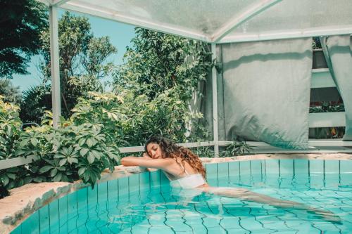una mujer en una piscina en Eili Suites en Moshav Ramot