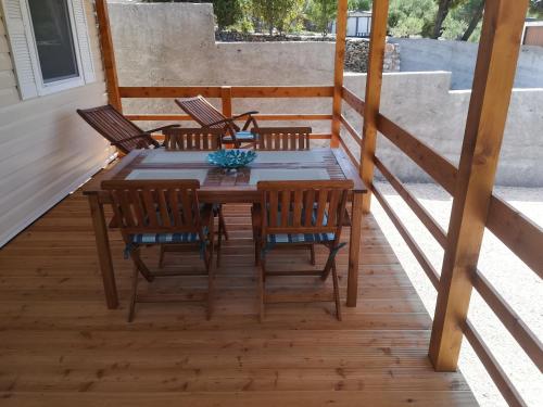 una mesa de madera y sillas en una terraza en Kamp Lunga, en Jezera