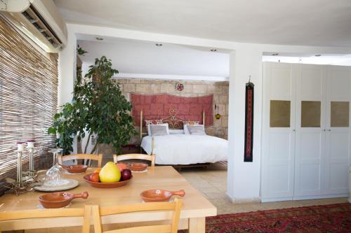 um quarto com uma mesa e um quarto com uma cama em Mikes Khan em Abū Ghaush