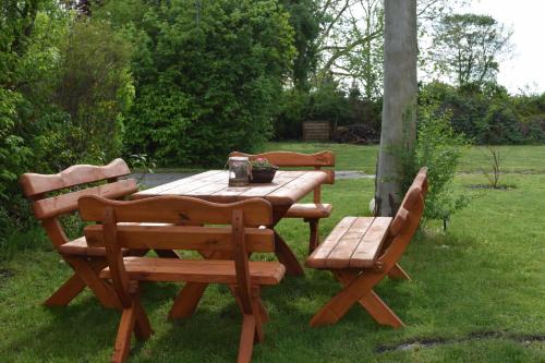 a wooden table and two chairs around a wooden table at Gut Kuhfs in Großzössen