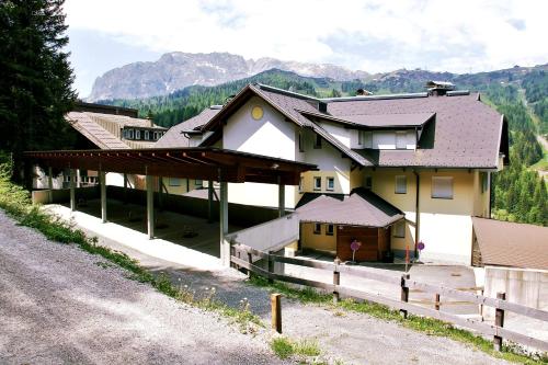 a house with a fence next to a road at Apartments Bergblick in Sonnenalpe Nassfeld