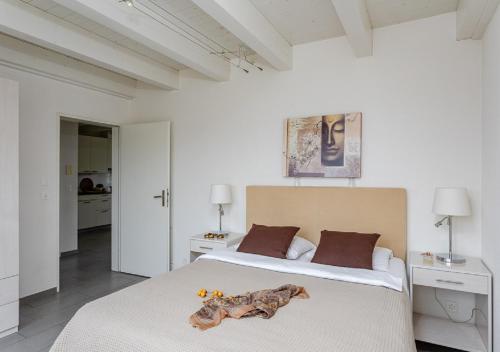 Swiss Star District 11 - Self Check-In في زيورخ: غرفة نوم بيضاء مع سرير أبيض كبير مع حيوانات محشوة عليها