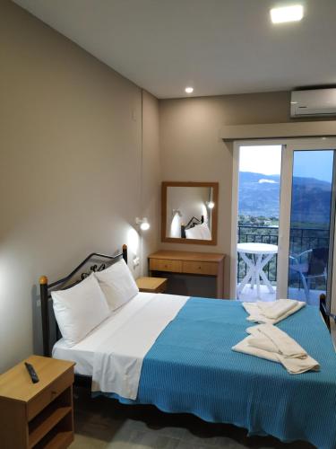 a bedroom with a bed and a large window at San Pedro in Vasiliki