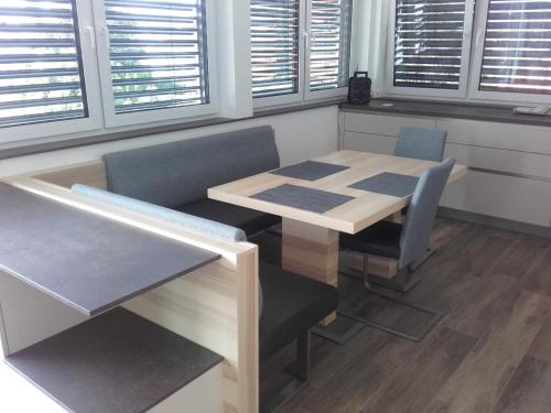a table and chairs in a room with windows at Apartment and more in Klagenfurt