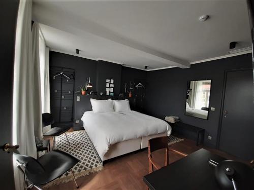 Schlafzimmer mit einem weißen Bett und schwarzen Wänden in der Unterkunft Broel4 in Kortrijk