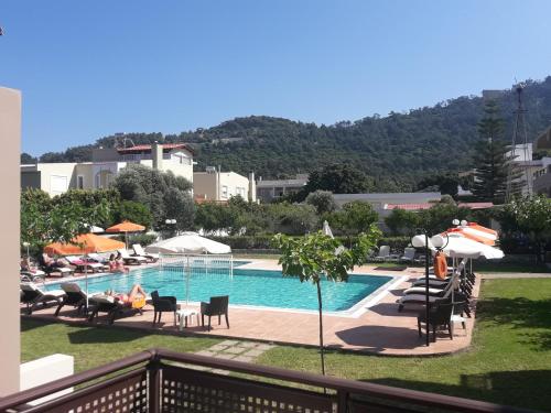 uitzicht op een zwembad met stoelen en parasols bij Santa Helena Hotel in Ialyssos