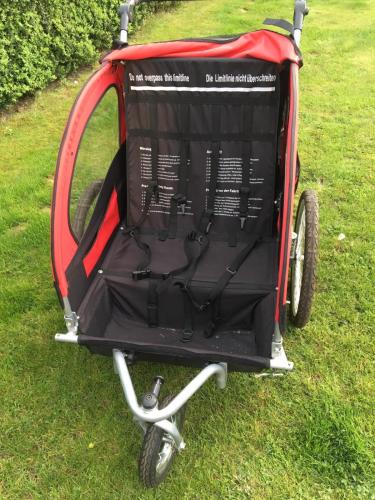 a red and black cart sitting in the grass at ubytování u Smolíků in Třeboň