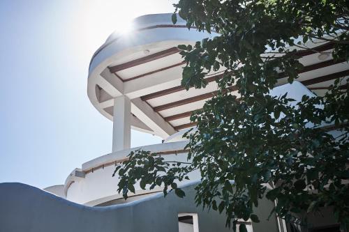 a white building with a tree in front of it at Casa Caracola in Tubará