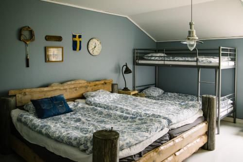 a bedroom with two bunk beds and a clock on the wall at Brännö Varv Bed & Breakfast in Brännö