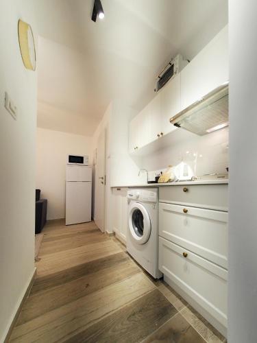 a laundry room with a washer and a washing machine at Studio Ariana and patio in Bat Yam