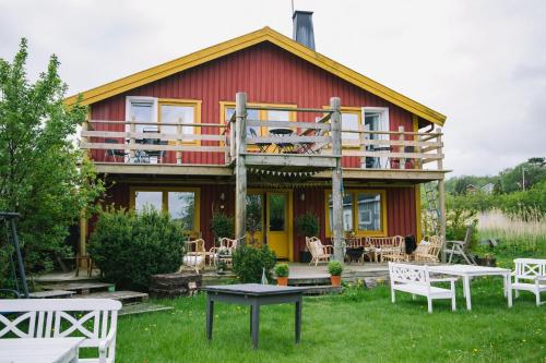 una casa roja con una terraza y mesas delante de ella en Brännö Varv Bed & Breakfast, en Brännö