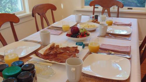 a table with breakfast foods and orange juice on it at Carriage House On Kent in Niagara on the Lake