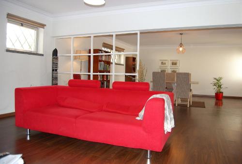 a red couch sitting in a living room at Vinaika Loft in Oeiras