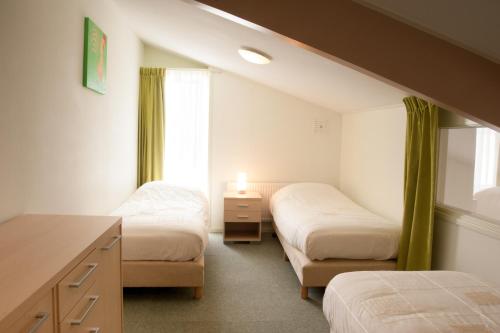 מיטה או מיטות בחדר ב-Apartement De Vosseburch